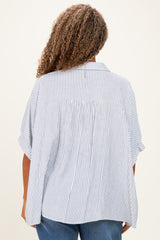 woman wearing a loose-fitting blue and white striped plus size blouse, view from the back