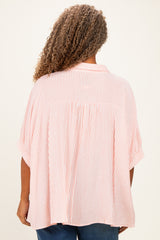 woman wearing a pink and white striped plus size blouse with short sleeves, viewed from the back