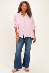 woman wearing a pink and white striped button-up shirt with oversized sleeves and blue flared jeans