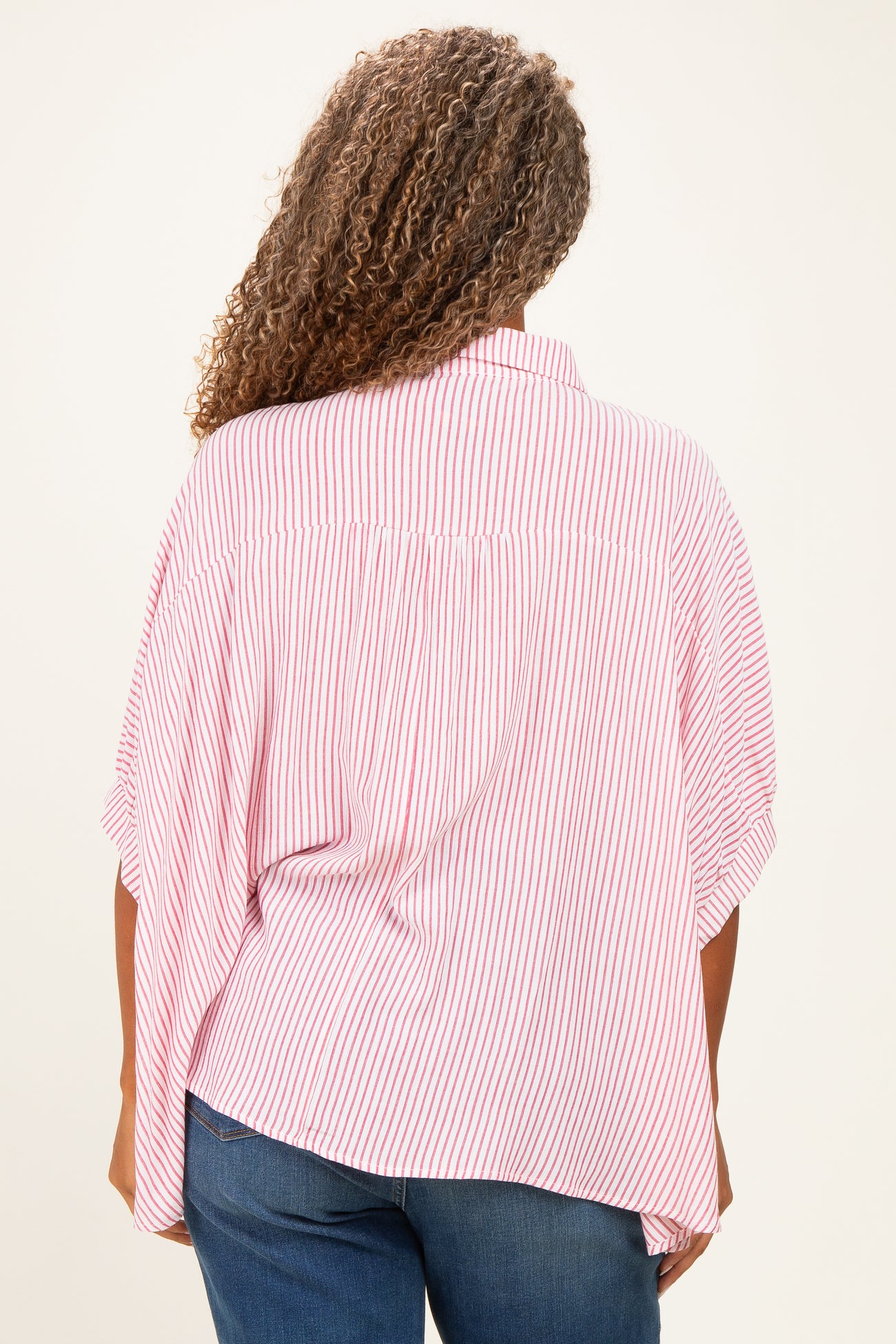plus-size woman wearing a red and white striped oversized blouse with flutter sleeves seen from the back