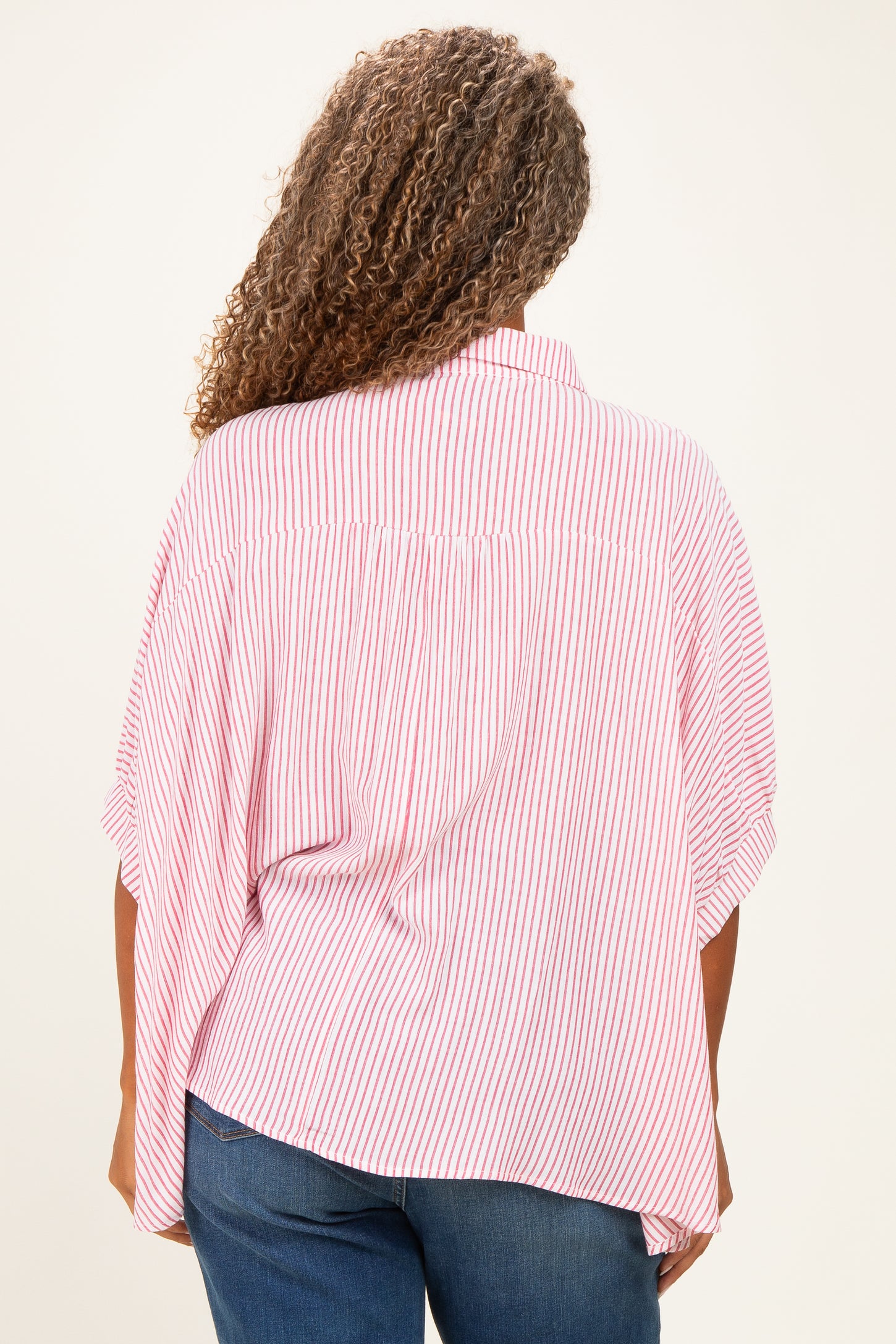 plus-size woman wearing a red and white striped oversized blouse with flutter sleeves seen from the back