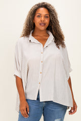 woman wearing a beige and white striped plus size button-up shirt with rolled sleeves and an asymmetrical hem