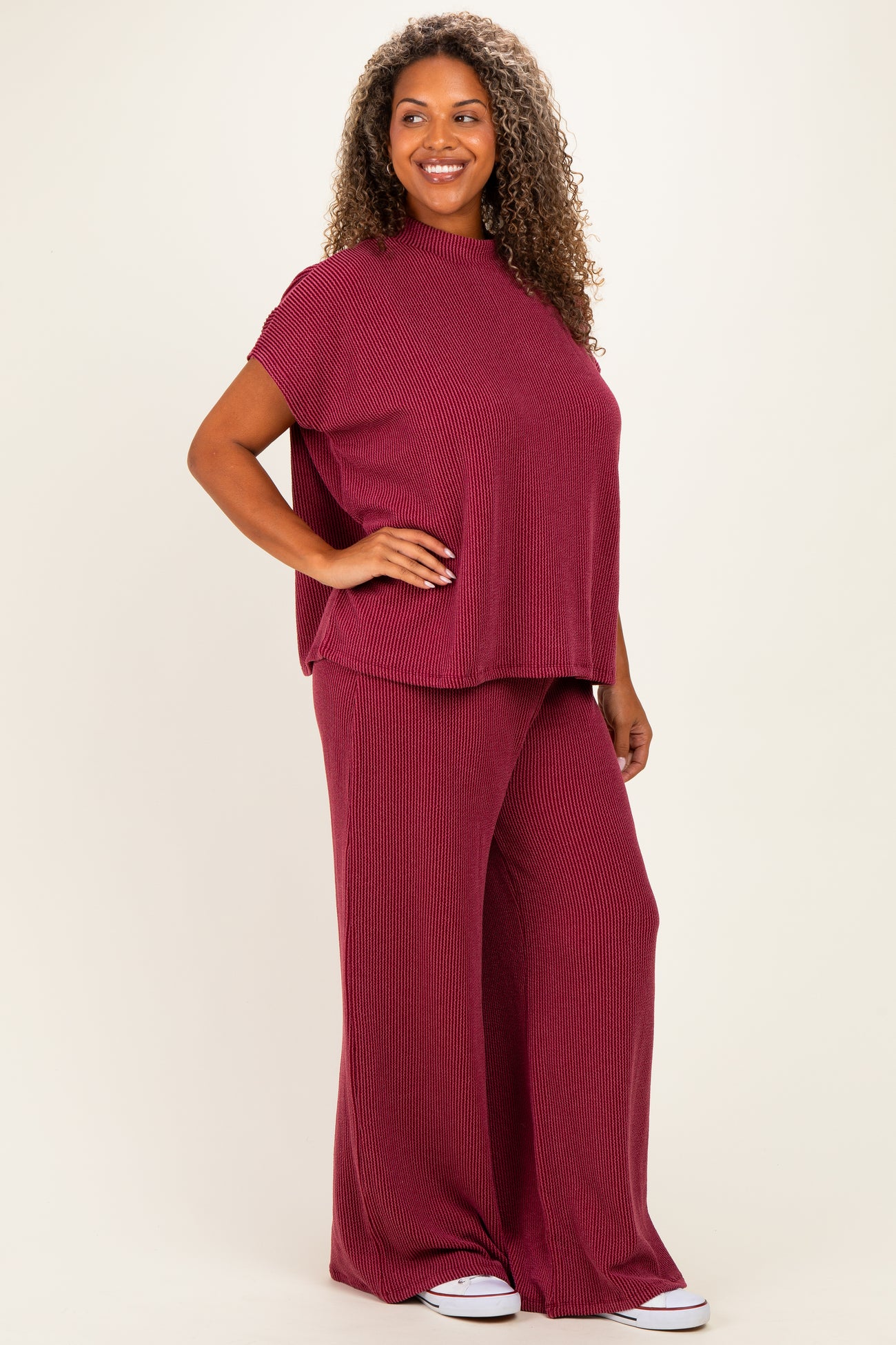 woman wearing a maroon knitted short sleeve top and matching wide-leg pants in a relaxed fit