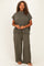 woman wearing a dark green striped plus size lounge set with a short-sleeve top and wide-leg pants