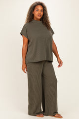 woman wearing a dark olive green plus-size ribbed matching set with a short sleeve top and wide-leg pants