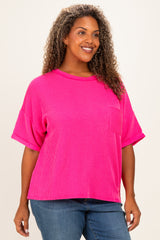 woman wearing a bright pink plus size ribbed t-shirt with short sleeves and a front pocket