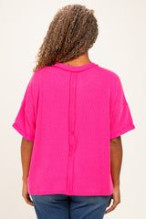 woman wearing a bright pink short sleeve plus size top with a button detail down the back