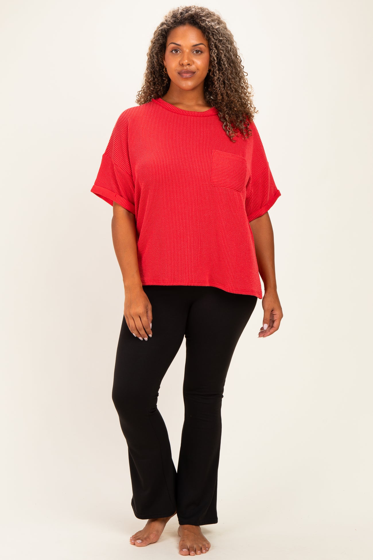 woman wearing a red ribbed short sleeve top with a pocket and black flared pants