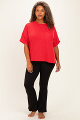 woman wearing a red ribbed short sleeve top with a pocket and black flared pants