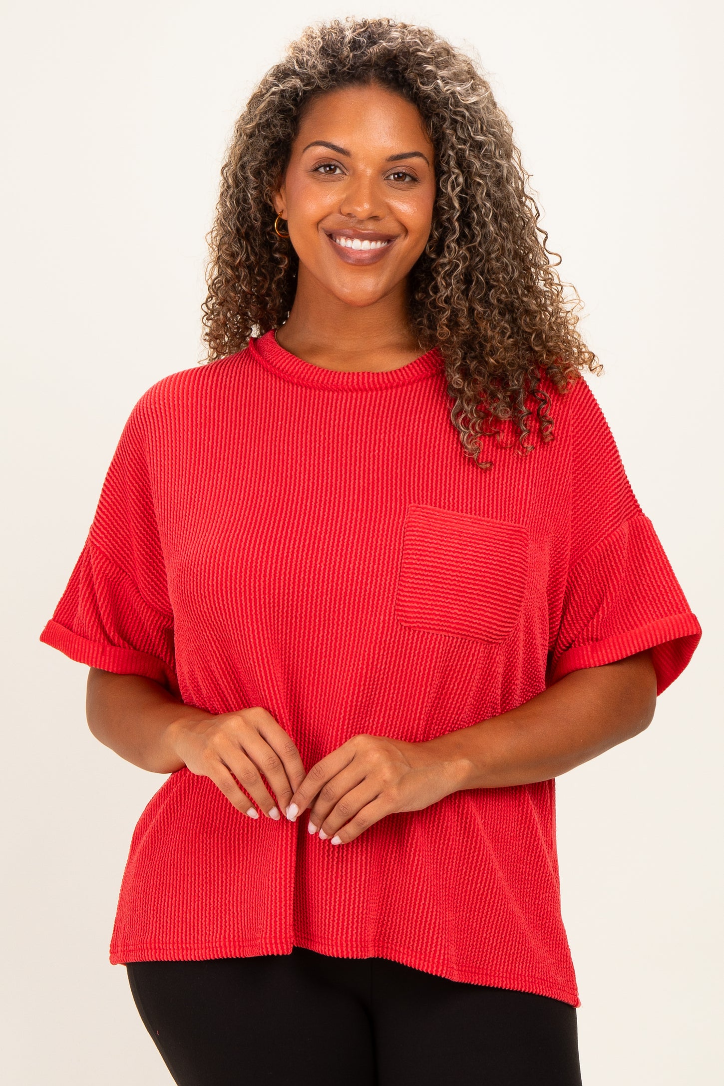 woman wearing a red short sleeve plus size top with a textured fabric and a front pocket