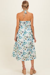maternity wear floral print halter neck midi dress with a fitted bodice and a flowing skirt, model seen from the back