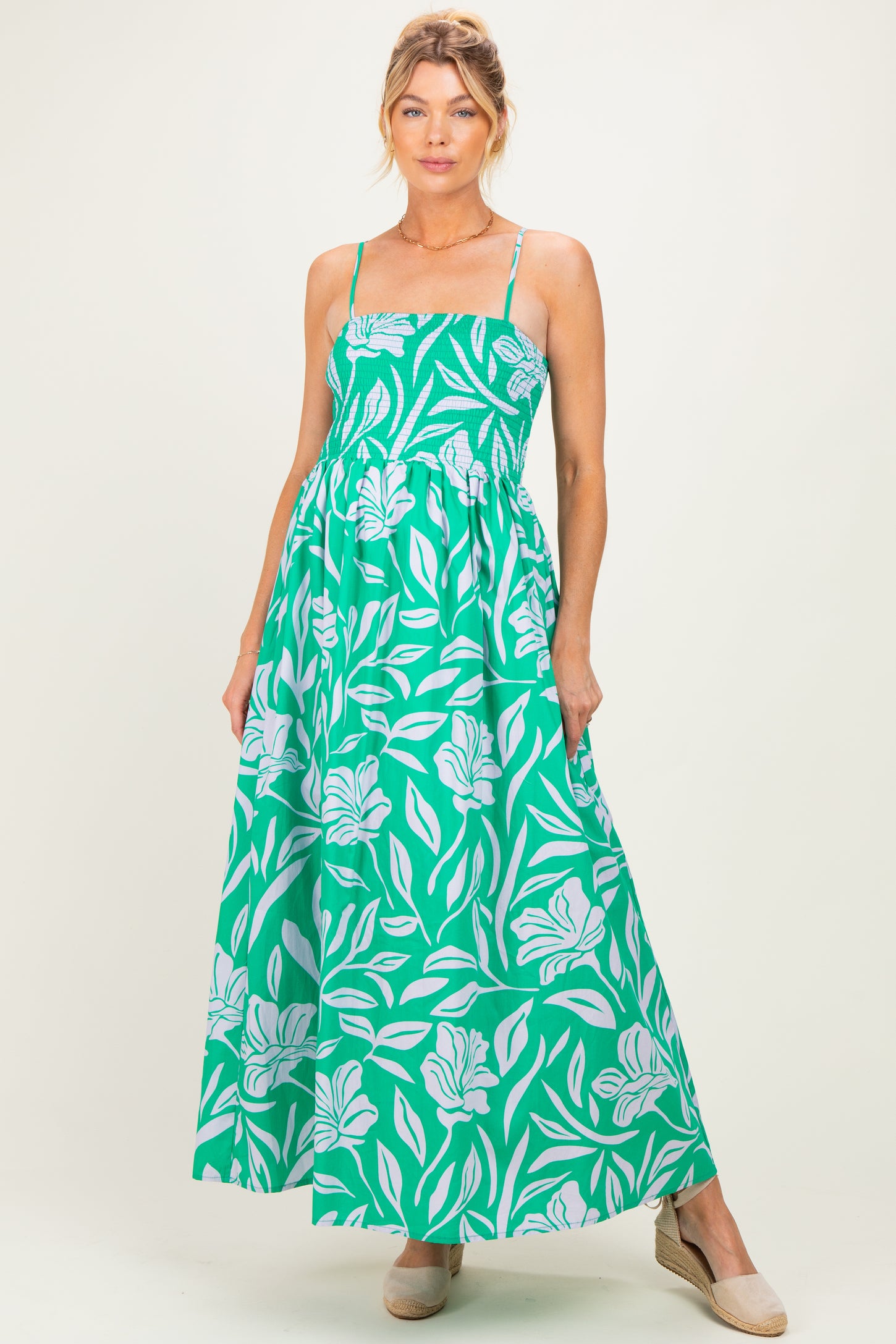 woman wearing a green floral maternity maxi dress with adjustable straps and a fitted bodice, baby bump visible