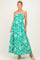 woman wearing a green floral maternity maxi dress with adjustable straps and a fitted bodice, baby bump visible