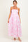 woman wearing a pink floral maternity maxi dress with spaghetti straps and a smocked bodice, showcasing a baby bump