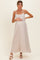 woman wearing a light beige maternity maxi dress with a tie detail at the waist and holding her baby bump