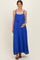 woman wearing a bright blue maternity maxi dress with adjustable straps and a tie detail, holding her baby bump