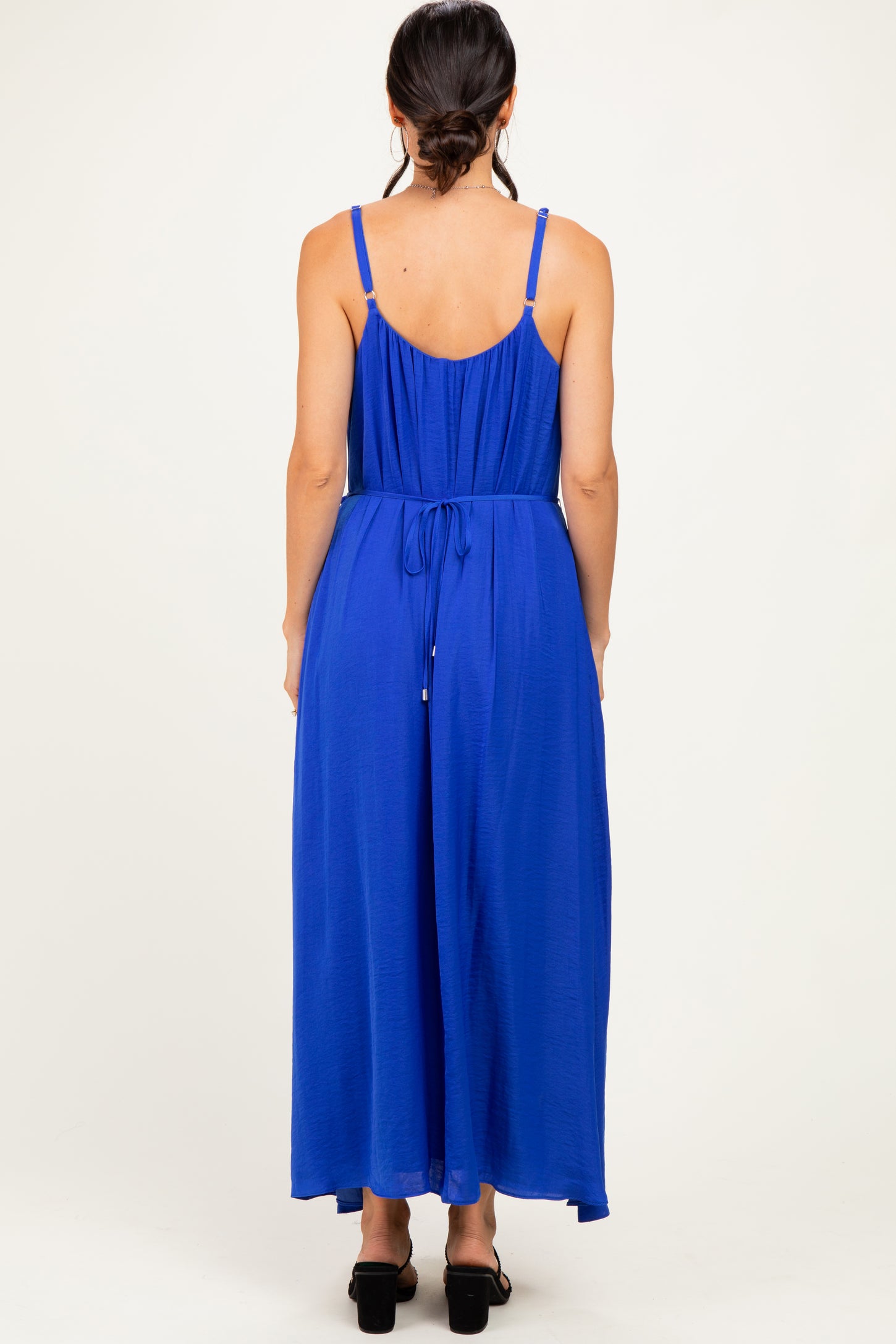 woman wearing a royal blue sleeveless maxi dress with adjustable straps and a cinched waist, viewed from the back