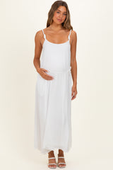 woman wearing a white maternity maxi dress with adjustable straps and a drawstring waist, holding her baby bump