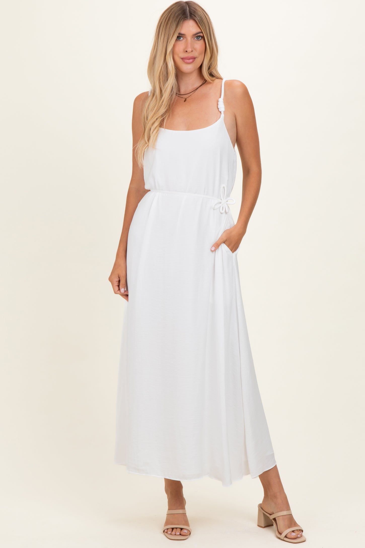 woman wearing a white maxi dress with adjustable spaghetti straps and a side pocket
