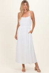 woman wearing a white maxi dress with adjustable spaghetti straps and a side pocket