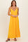 woman wearing a bright yellow maxi dress with a v-neckline and thin straps, standing confidently
