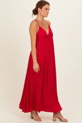 woman wearing a flowy red maxi dress with a deep V-neckline and spaghetti straps