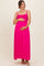 woman wearing a bright pink maternity maxi dress with smocked bodice and holding her baby bump