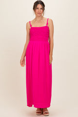 woman wearing a bright pink maternity maxi dress with a smocked bodice and adjustable straps