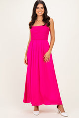 woman wearing a bright pink maxi dress with a smocked bodice and a flowy skirt