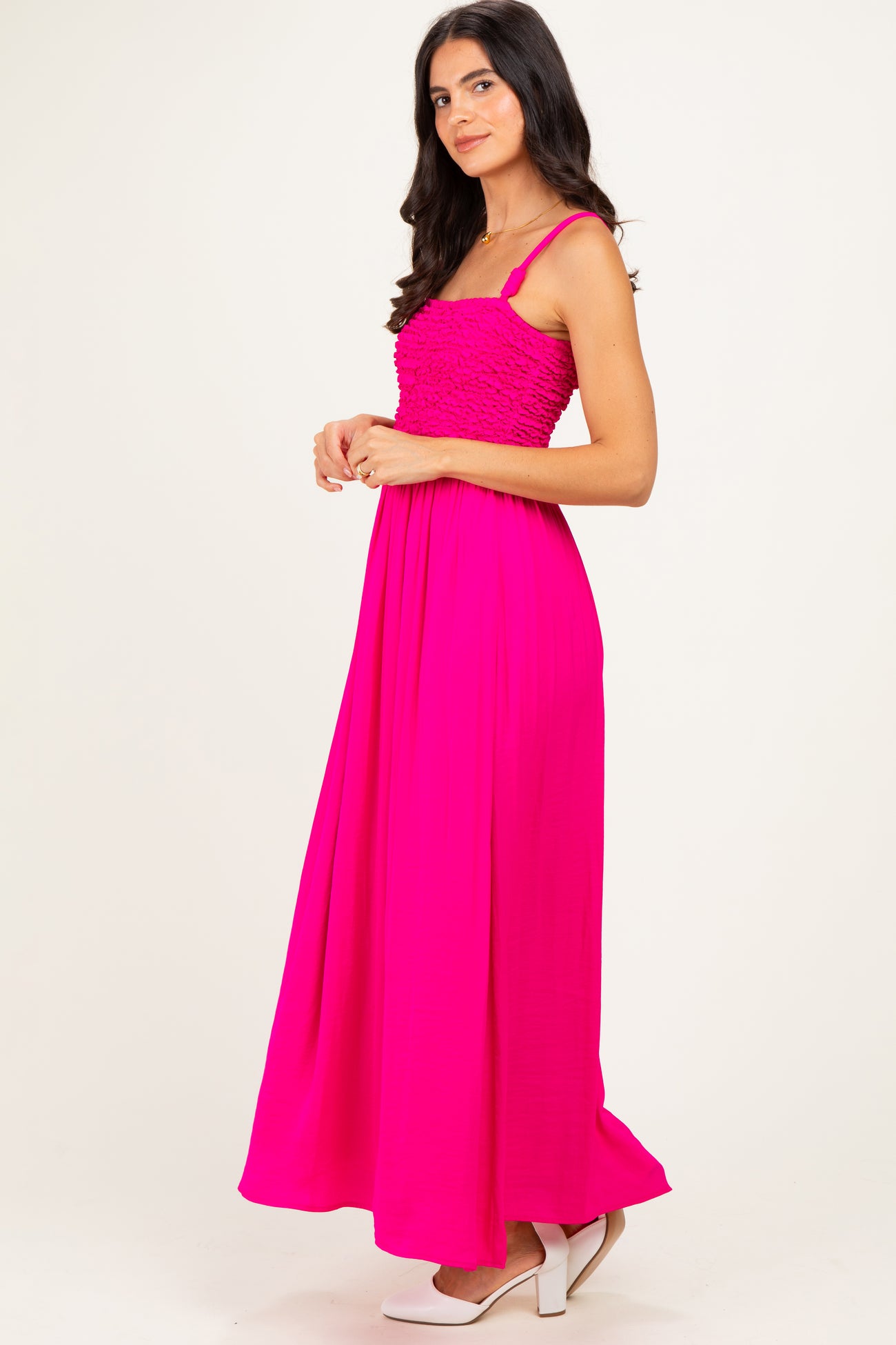 woman wearing a vibrant pink maxi dress with smocked bodice and spaghetti straps