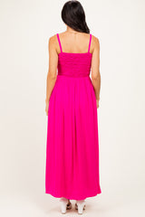 woman wearing a bright pink maxi dress with a smocked bodice and adjustable spaghetti straps, shown from the back