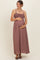 woman wearing a mauve maternity maxi dress with a smocked bodice, cradling her baby bump
