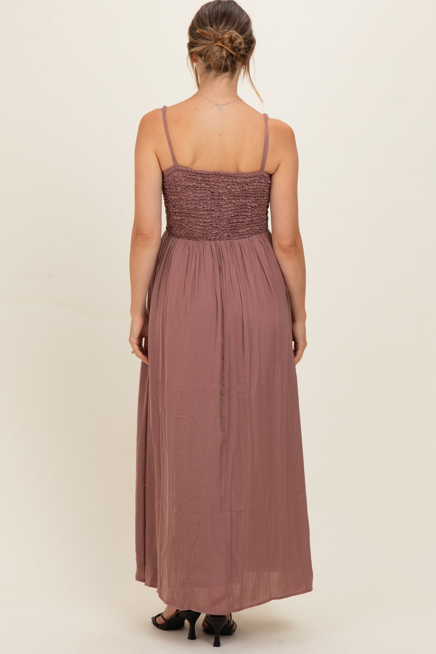 woman wearing a burgundy maternity maxi dress with a smocked bodice and flowing skirt, seen from the back