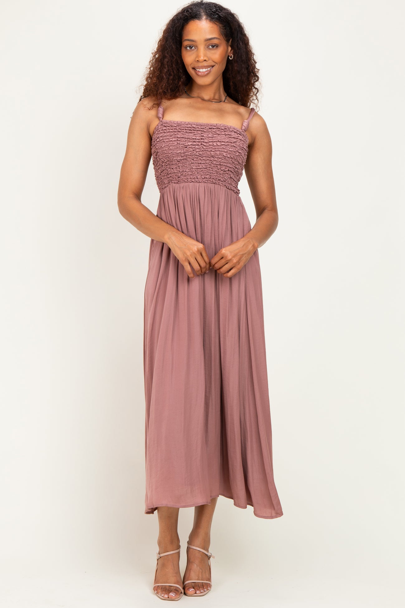 woman wearing a mauve sleeveless maxi dress with smocked bodice and thin shoulder straps