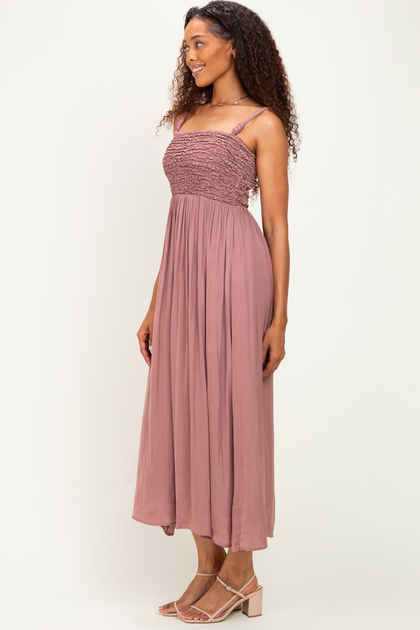 woman wearing a mauve smocked bodice maxi dress with spaghetti straps and flowy skirt