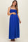 woman wearing a bright blue maternity maxi dress with a smocked bodice and holding her baby bump