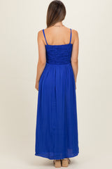 woman wearing a royal blue maternity maxi dress with a smocked bodice and adjustable straps from the back