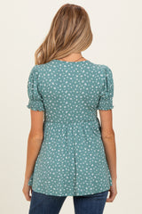 woman wearing a teal maternity top with puff sleeves and a floral print, showing a baby bump from the back