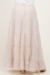 woman wearing a flowy white maxi skirt with a floral print and tiered design, viewed from the back