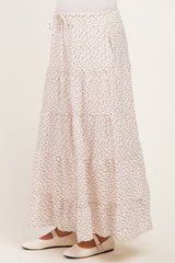 maternity wear white tiered maxi skirt with a floral print and side pockets, styled with a tied waist and a model wearing it