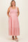 woman wearing a pink striped maternity plus maxi dress with a smocked bodice and pockets, smiling at the camera