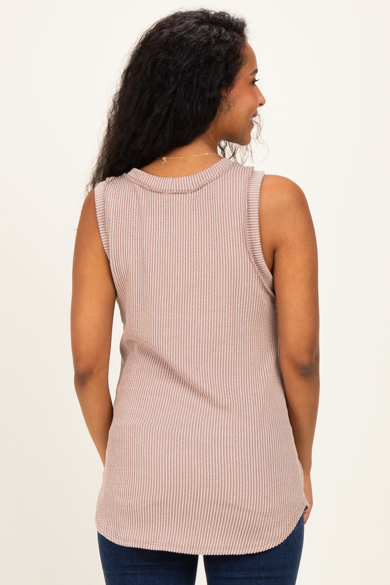 woman wearing a relaxed fit beige ribbed sleeveless maternity top, seen from the back