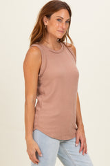 woman wearing a taupe sleeveless ribbed top with a relaxed fit and curved hemline, styled with light blue jeans