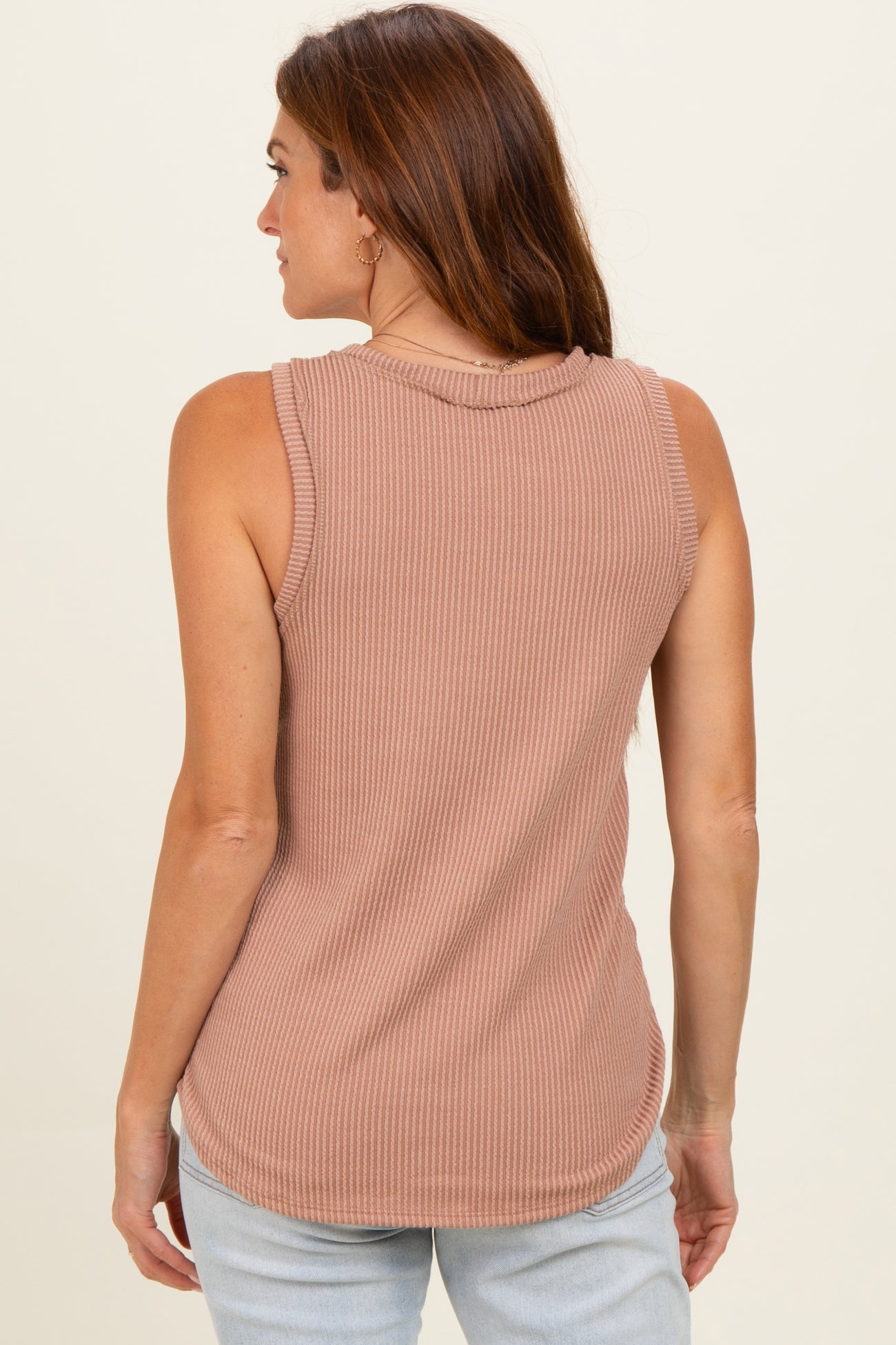 woman wearing a taupe ribbed sleeveless top, view from the back, paired with light blue jeans