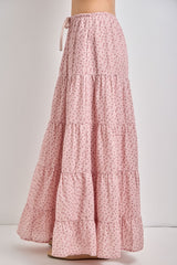 woman wearing a long pink floral tiered maxi skirt with a drawstring waist