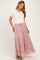 woman wearing a light pink tiered maternity maxi skirt with floral pattern and a white short sleeve top