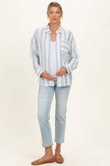 woman wearing a white and blue striped maternity shirt and light wash jeans, gently cradling her baby bump