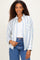 woman wearing a white and blue striped button-up shirt with a front pocket, paired with high-waisted jeans