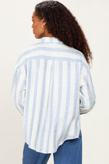 woman wearing a white and blue striped oversized shirt, seen from the back, with loose curls cascading down her shoulders