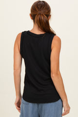 woman wearing a black ribbed sleeveless top, seen from the back, styled with light blue wide-leg jeans
